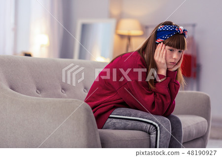 Thoughtful brunette pupil looking downwards at floor 48190927