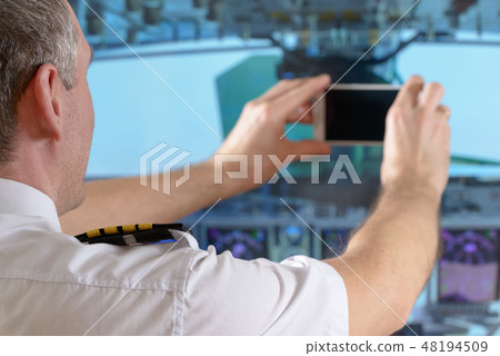 Airline pilot using smart phone 48194509