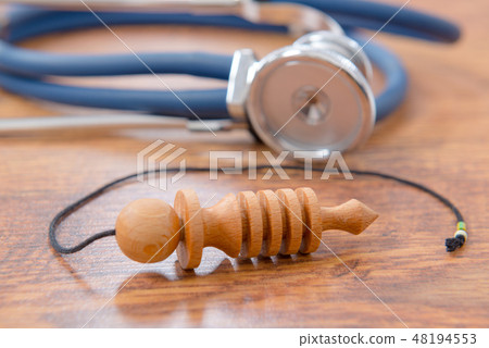 Pendulum and stethoscope on a wooden table Pendulum and stethoscope on a wooden table 48194553
