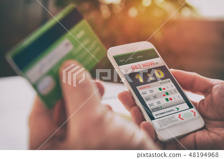 Man betting on sports with smartphone 48194968