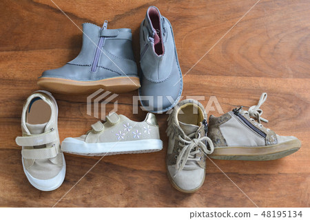 Different girl's shoes on a wooden background 48195134