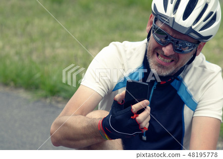 Injured biker holding smartphone calling rescue 48195778