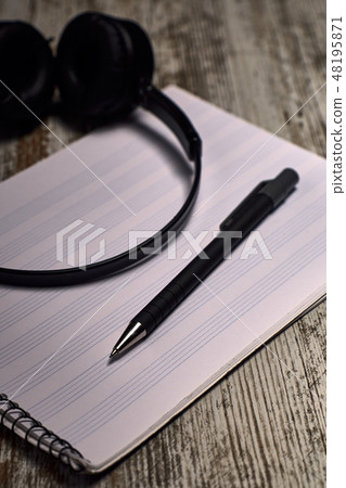 headphones next to an empty pentagram notebook headphones next to an empty pentagram notebook 48195871