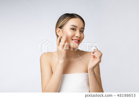 Asian woman applying cosmetic cream on skin on isolated white background Asian woman applying cosmetic cream on skin on isolated white background 48198653