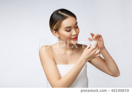 Asian woman applying cosmetic cream on skin on isolated white background 48198659