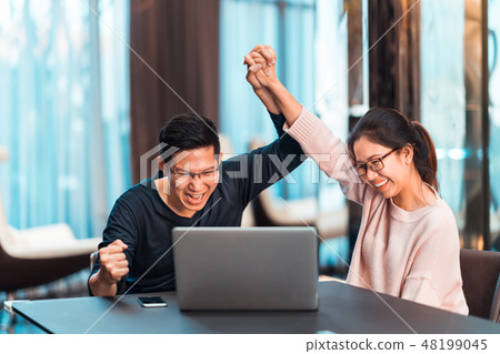 Young Asian couple celebrate together with laptop 48199045