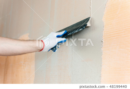 The worker's hand with a wide spatula. The worker's hand with a wide spatula. 48199440
