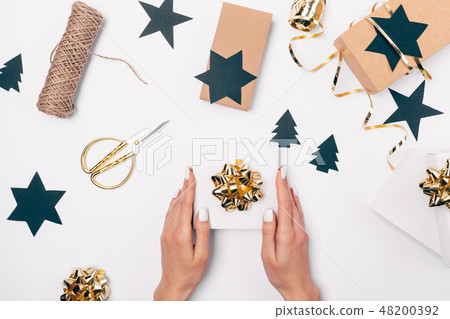 Top view woman's hands holding Christmas gift Top view woman's hands holding Christmas gift 48200392