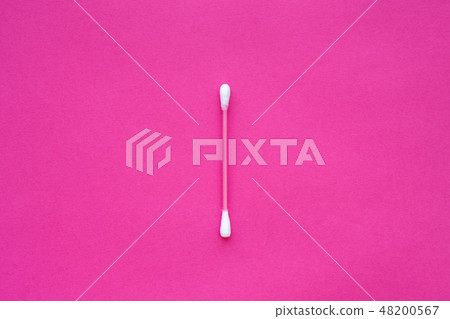 pink cotton buds with white heads laid out on pink 48200567