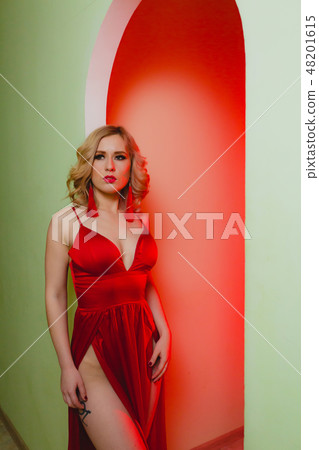 Close-up portrait of sexy blonde woman in the red dress in a studio 48201615