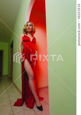 Young sexy blonde woman in the red dress with high slit 48201616