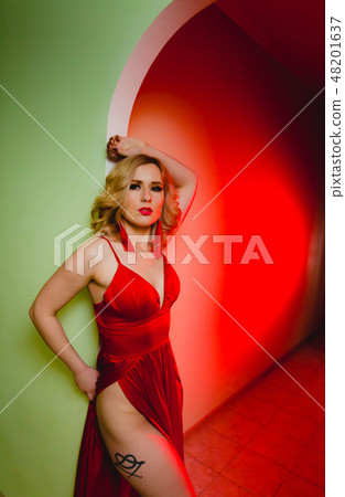 Close-up portrait of sexy blonde woman in the red dress in a studio 48201637