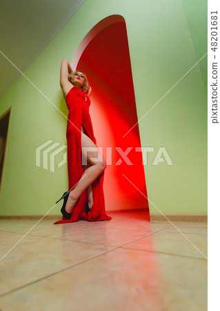 Attractive blonde model in the red dress with high slit and long naked legs Attractive blonde model in the red dress with high slit and long naked legs 48201681