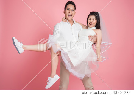 groom carrying his bride in casual wedding dress groom carrying his bride in casual wedding dress 48201774