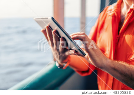 chief officer or captain on deck of vessel or ship watching digital tablet chief officer or captain on deck of vessel or ship watching digital tablet 48205828