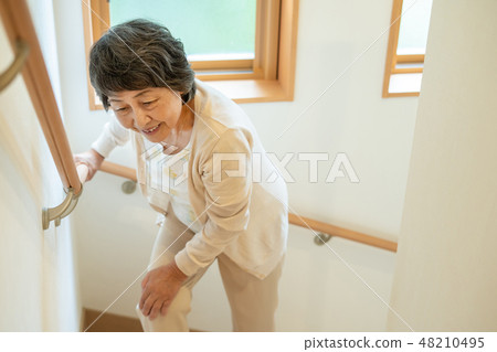 Senior female elderly old man going up stairs Senior female elderly old man going up stairs 48210495