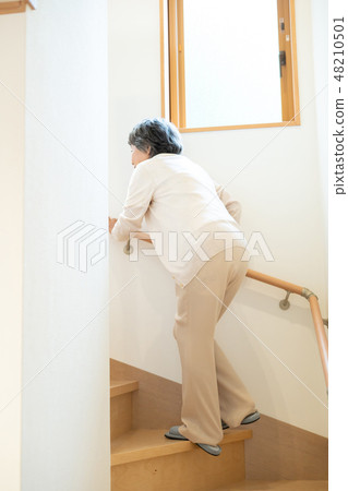 Senior female elderly old man going up stairs Senior female elderly old man going up stairs 48210501