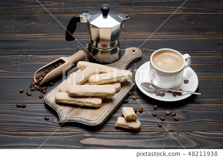 Italian Savoiardi ladyfingers Biscuits and cup of coffee on wooden backgound Italian Savoiardi ladyfingers Biscuits and cup of coffee on wooden backgound 48211938