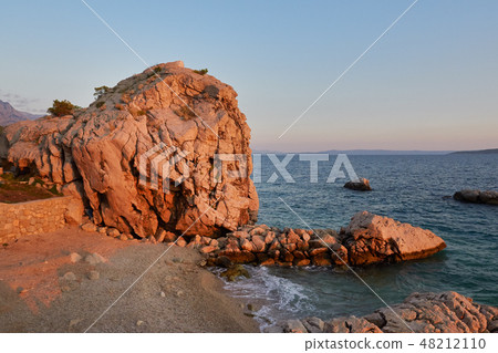 Rock island at sunset in small mediterranean Rock island at sunset in small mediterranean 48212110