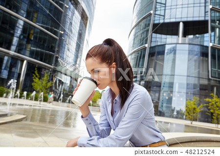 Beautiful young businesswoman with a disposable coffee cup Beautiful young businesswoman with a disposable coffee cup 48212524