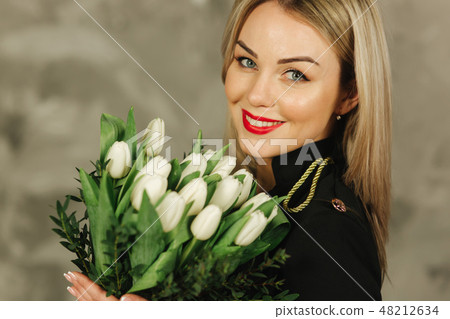 Portrait of beautiful mother hold a bouquet of white tulips on 8th of march. Flowers in woman's hand Portrait of beautiful mother hold a bouquet of white tulips on 8th of march. Flowers in woman's hand 48212634