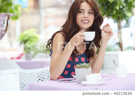 woman thinking in a coffee shop terrace in the street woman thinking in a coffee shop terrace in the street 48213638