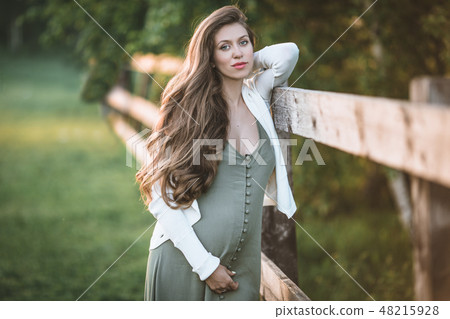 Pregnant pretty woman is posing in spring park Pregnant pretty woman is posing in spring park 48215928