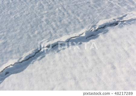 Crack on the snow river in the spring 48217289