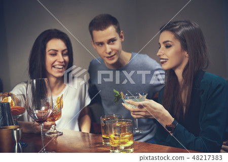 Photo of joyful friends in the bar communicating with each other Photo of joyful friends in the bar communicating with each other 48217383