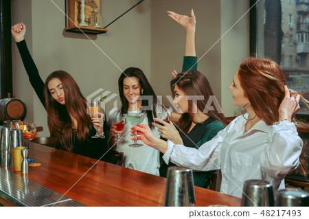 Friends having a drinks at bar 48217493