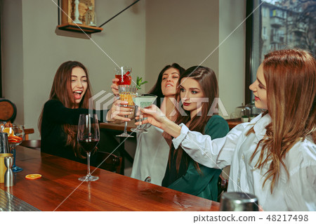 Friends having a drinks at bar 48217498