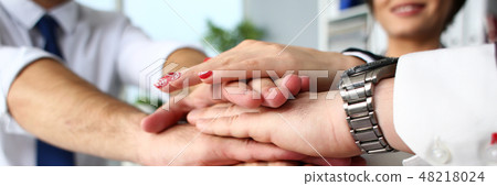 Group of people in suits crossed hands in pile 48218024