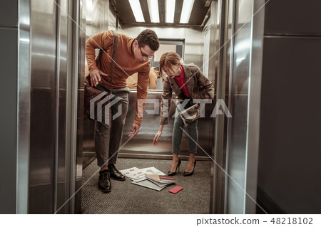 Helpful boyfriend assisting his woman after dropping papers 48218102
