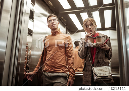 Couple of businessmen taking the elevator while going to work Couple of businessmen taking the elevator while going to work 48218111