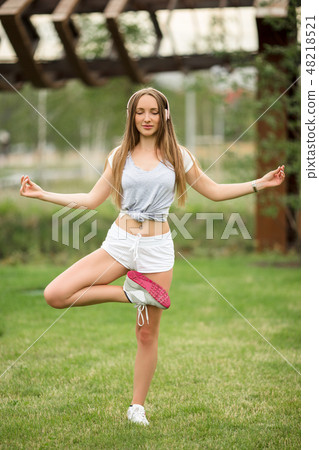 Young sportive girl doing yoga in park in the city Young sportive girl doing yoga in park in the city 48218521