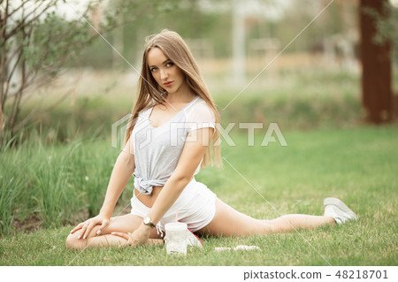 Young sportive girl doing stretching in park in the city Young sportive girl doing stretching in park in the city 48218701