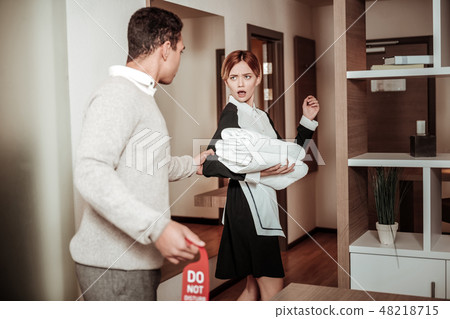 Man grasping arm of housekeeper planning harassing her 48218715