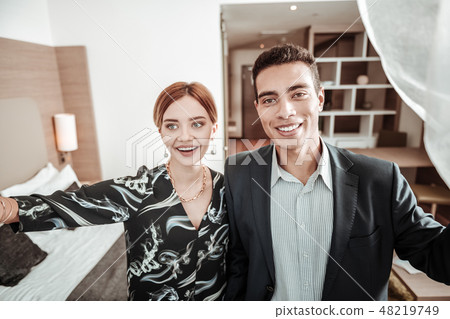 Beaming husband and wife looking into window enjoying view 48219749