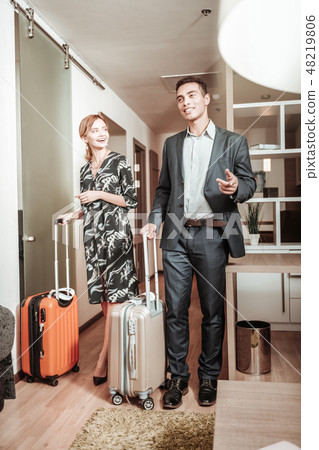 Husband and wife caring their luggage while entering hotel room 48219806
