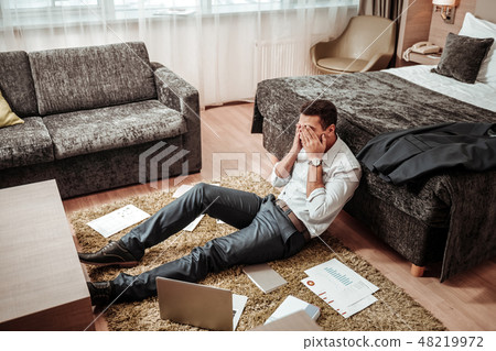 Young man feeling extremely tired after working all day Young man feeling extremely tired after working all day 48219972