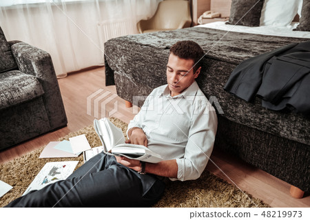Smart African-American man reading interesting financial book 48219973