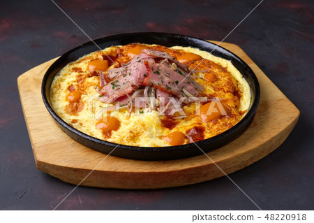 Omelette with bacon and onion on cast-iron pan 48220918
