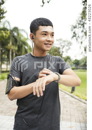 Sportsman checking stopwatch Sportsman checking stopwatch 48223026