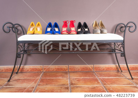 Collection of woman high heel shoes, on white sofa . Collection of woman high heel shoes, on white sofa . 48223739