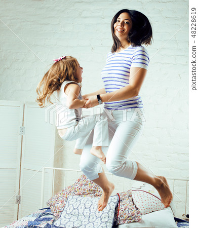 Portrait of mother and daughter laying in bed and smiling close up, lifestyle family people concept Portrait of mother and daughter laying in bed and smiling close up, lifestyle family people concept 48228619