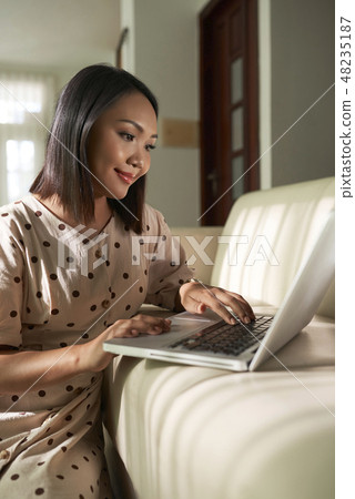 Smiling woman working on laptop 48235187