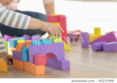 Boy playing with building blocks 48235966
