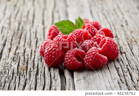 Raspberry on wooden board Raspberry on wooden board 48236762