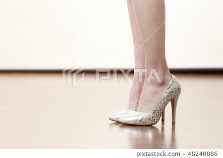 Woman wearing silver high heels Woman wearing silver high heels 48240086