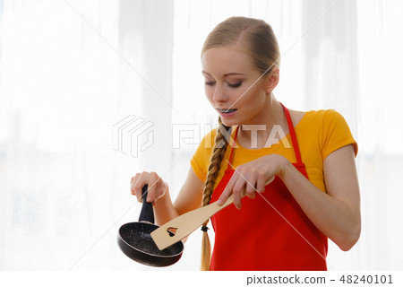 Woman holding cooking pan and spatula 48240101